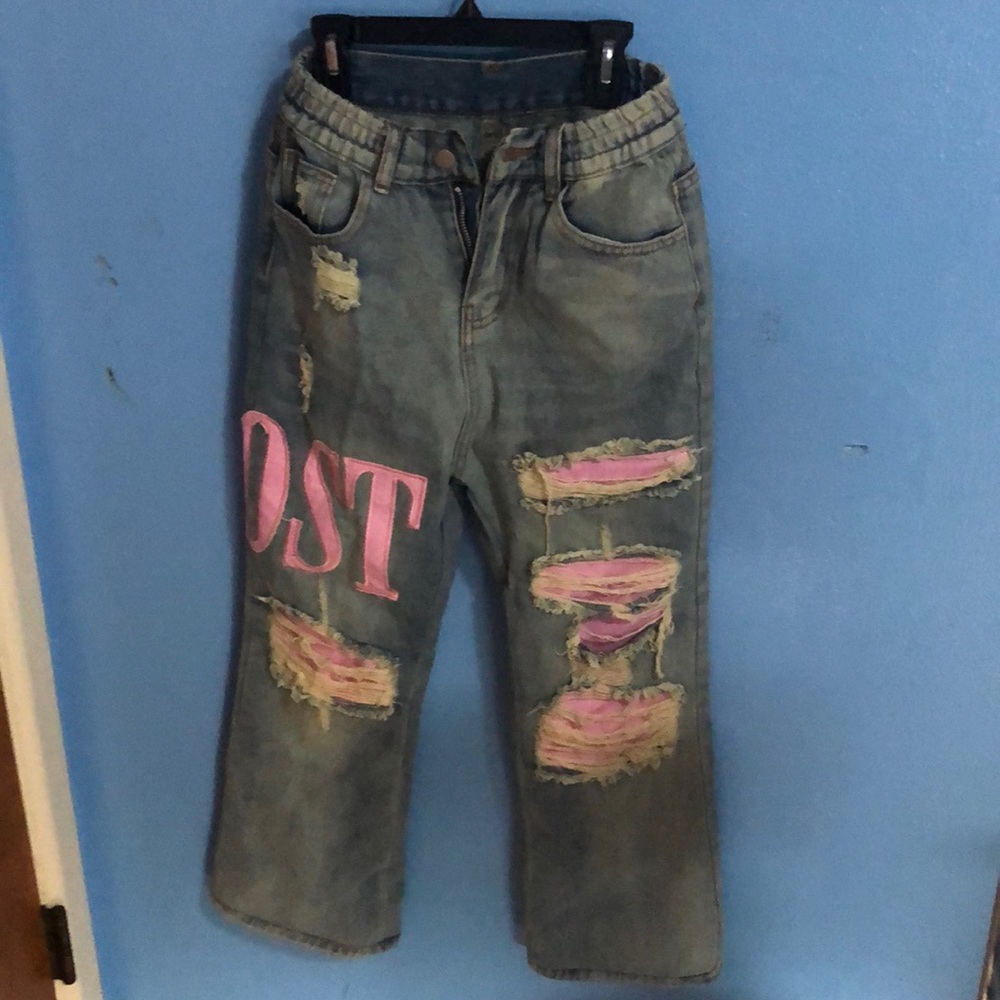 Distresses pink on blue jeans